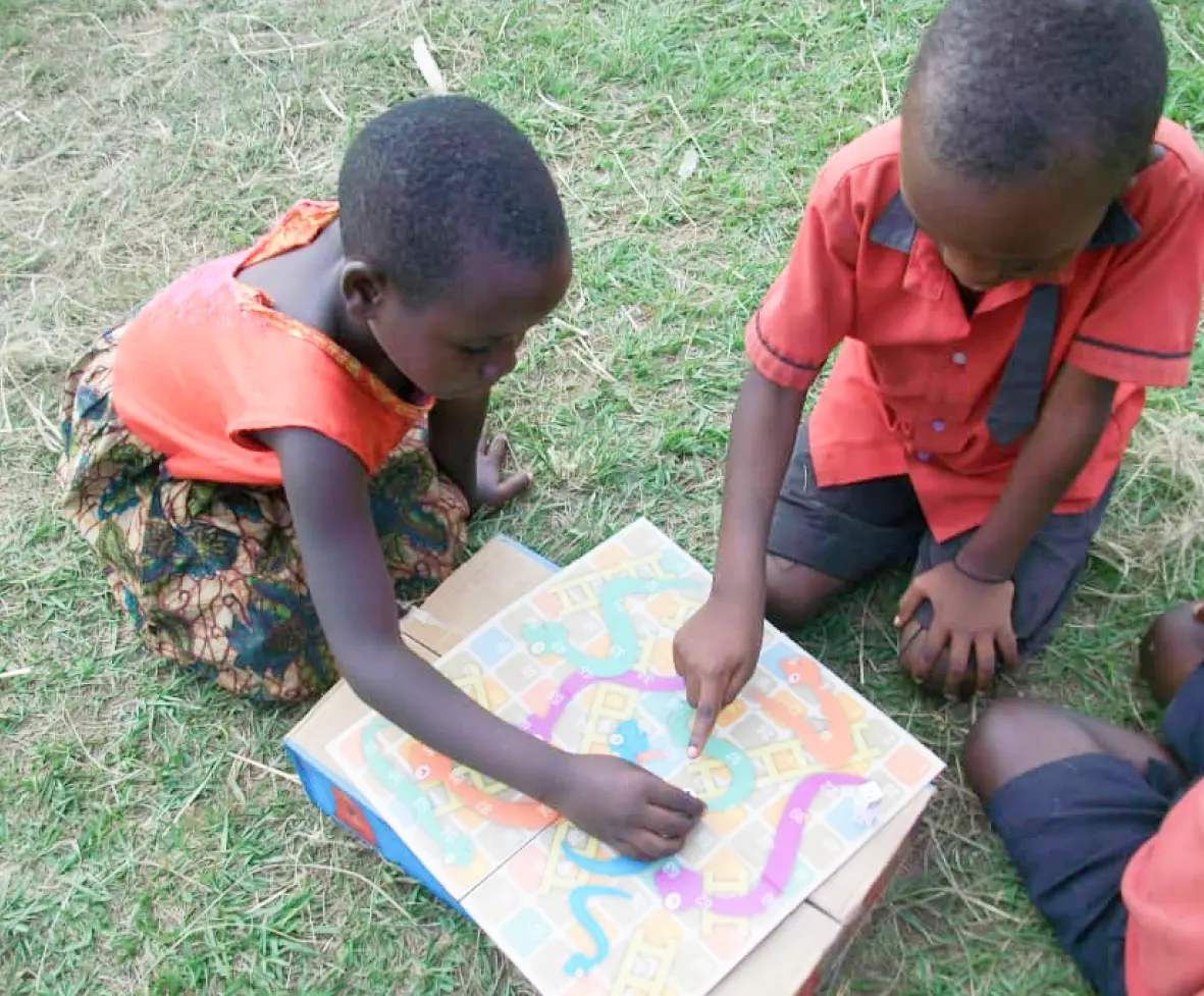 Children playing a board game on the grass